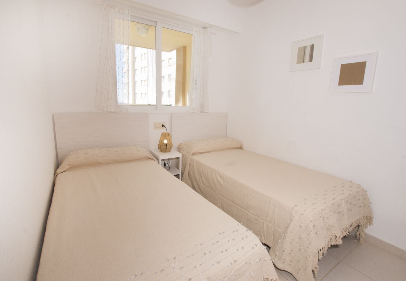 Dormitorio con dos camas individuales y balcón