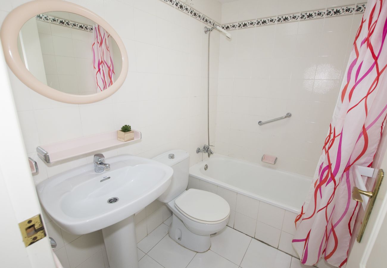 Salle de bain avec douche, lavabo et miroir 