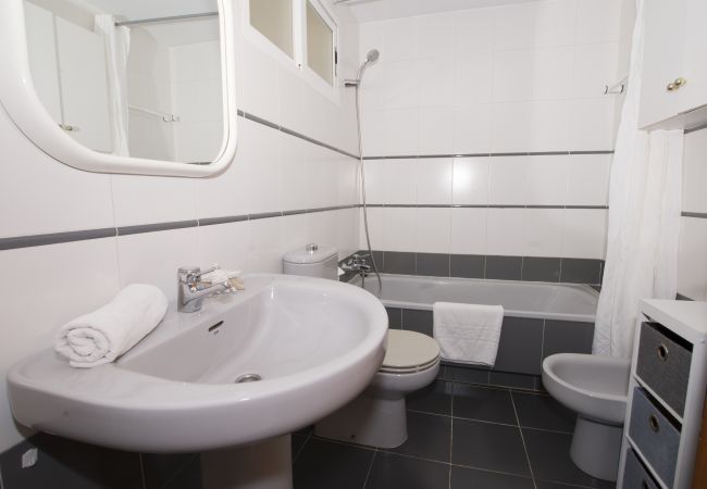 Lavabo avec miroir et baignoire dans la salle de bain